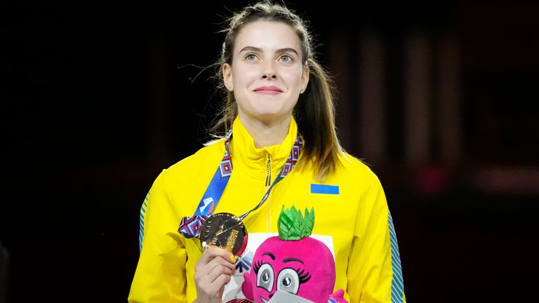 Yaroslava Mahuchikh, of Ukraine, stands with her gold medal on the podium after winning the Women's high jump at the World Athletics Indoor Championships in Belgrade, Serbia, Saturday, March 19, 2022. (AP Photo/Darko Vojinovic)