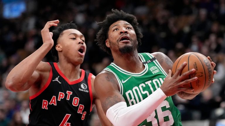 Toronto Raptors forward Scottie Barnes (4) tries to defend as Boston Celtics guard Marcus Smart (36) looks to the basket during first-half NBA basketball game action in Toronto, Monday, March 28, 2022. 