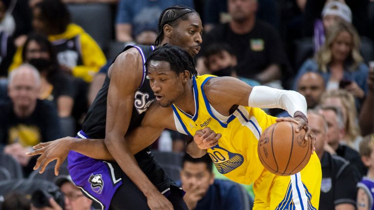 Golden State Warriors forward Jonathan Kuminga (00) is defended by Sacramento Kings forward Justin Holiday (9) during the second half of an NBA basketball game in Sacramento,