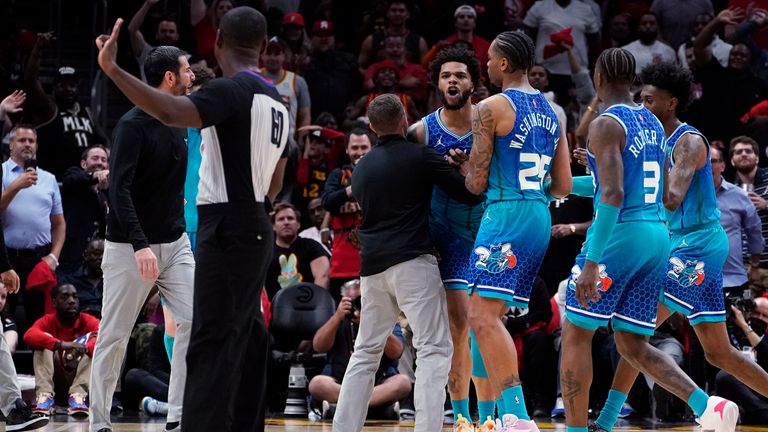 Charlotte Hornets forward Miles Bridges is restrained by P.J. Washington and others as he argues with a an official after being charged with a foul 