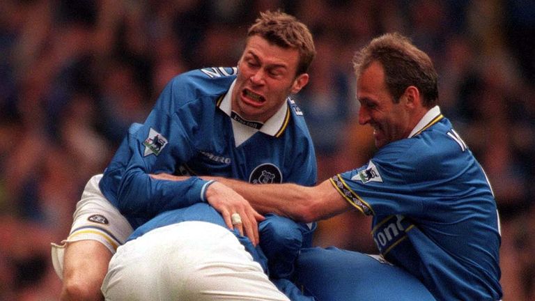 Duncan Ferguson (left) and Dave Watson (right) join the celebration as they pile on Everton goalscorer Gareth Farrelly his goal assured their place in the Premiership