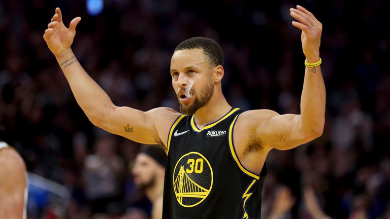Stephen Curry raises his arms to the Chase Center crowd to celebrate