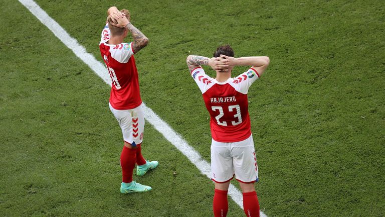 पियरे-एमिल होजबर्ज (दाएं) और डैनियल वास डरावने रूप में देखते हैं क्योंकि पैरामेडिक्स यूरो 2020 में डेनमार्क के पहले मैच के दौरान मिडफील्डर क्रिश्चियन एरिक्सन का इलाज करते हैं।