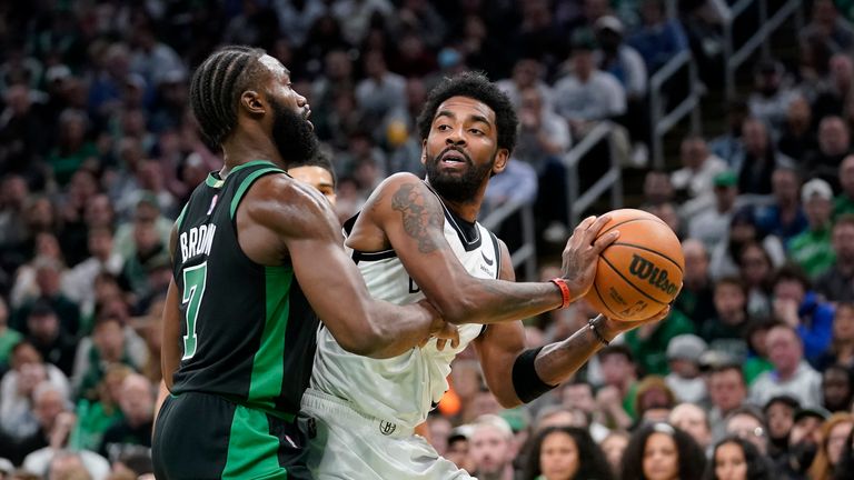 Boston Celtics guard Jaylen Brown, left, defends against Brooklyn Nets guard Kyrie Irving, right, in the second half of Game 1 of an NBA basketball first-round Eastern Conference playoff series, Sunday, April 17, 2022, in Boston. The Celtics won 115-114.