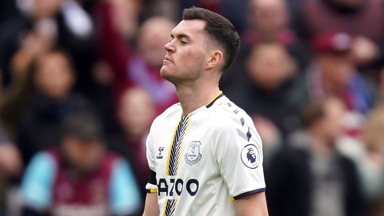 Michael Keane walks off the pitch after receiving a red card for his challenge on Michael Antonio