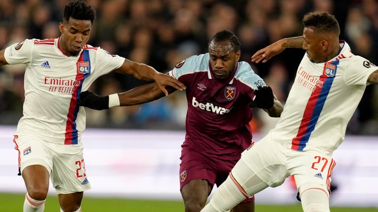 Michail Antonio challenges with Jerome Boateng, right, and Thiago Mendes during West Ham vs Lyon