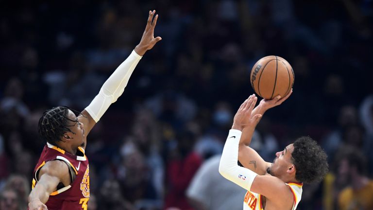 Atlanta Hawks' Trae Young, right, shoots against Cleveland Cavaliers' Isaac Okoro during the first half of an NBA play-in basketball game Friday, April 15, 2022, in Cleveland. 