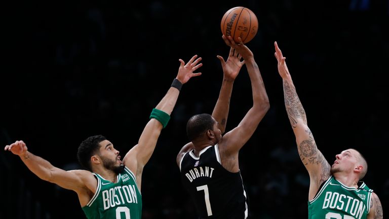Brooklyn Nets&#39; Kevin Durant (7) shoots between Boston Celtics&#39; Jayson Tatum (0) and Daniel Theis (27) during the second half of Game 2 of an NBA basketball first-round Eastern Conference playoff series, Wednesday, April 20, 2022, in Boston. (AP Photo/Michael Dwyer)