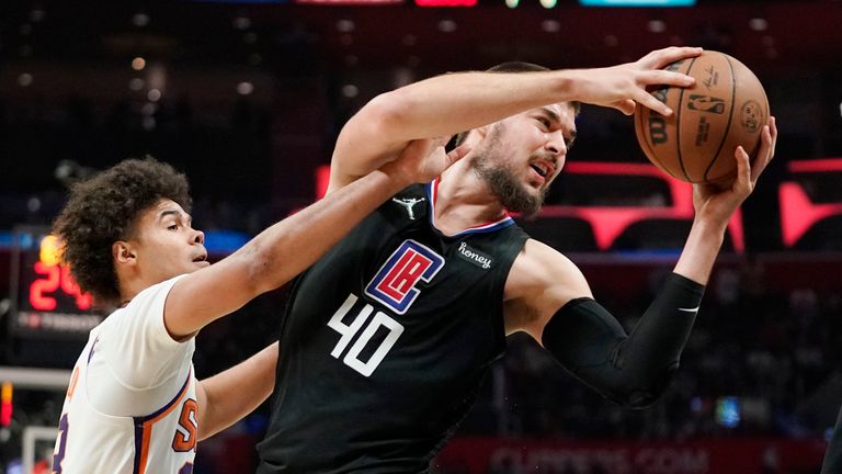 Phoenix Suns forward Cameron Johnson, left, reacts in on Los Angeles Clippers center Ivica Zubac during the second half of an NBA basketball game Wednesday, April 6, 2022, in Los Angeles. 