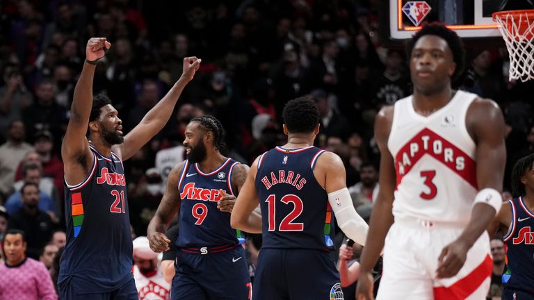 Toronto Raptors forward OG Anunoby (3) walks away as Philadelphia 76ers center Joel Embiid (21) celebrates the team's overtime win in Game 3 of an NBA basketball first-round playoff series, Wednesday, April 20, 2022, in Toronto .  (Nathan Denette/The Canadian Press via AP)