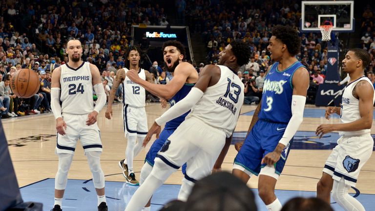 Minnesota Timberwolves center Karl-Anthony Towns, center left, reacts after scoring against the Memphis Grizzlies in the second half of Game 1 of a first-round NBA basketball playoff series Saturday, April 16, 2022, in Memphis, Tenn.