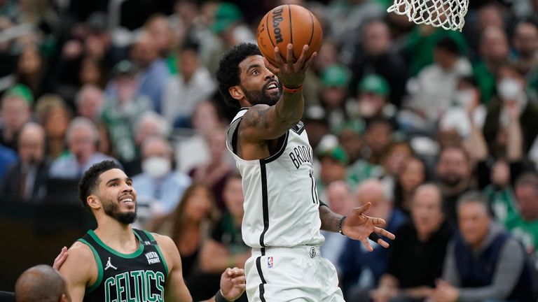 Brooklyn Nets guard Kyrie Irving (11) drives to the basket as Boston Celtics forward Jayson Tatum (0) looks on in the second half of Game 1 of an NBA basketball first-round Eastern Conference playoff series, Sunday, April 17, 2022, in Boston. The Celtics won 115-114.
