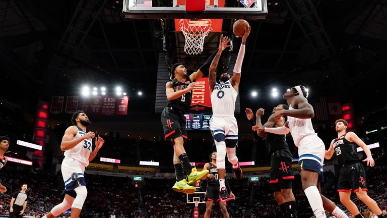 Minnesota Timberwolves guard D&#39;Angelo Russell (0) shoots as Houston Rockets forward Kenyon Martin Jr., left, defends during the second half of an NBA basketball game,