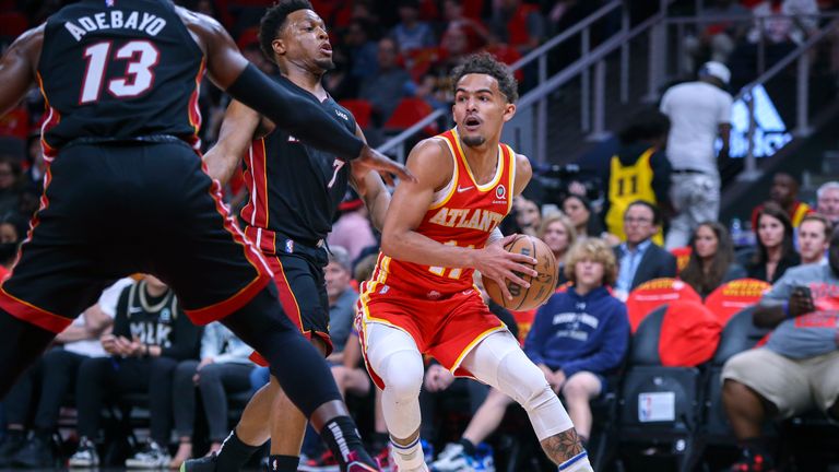 Atlanta Hawks' Trae Young, right, is defended by Miami Heat center Bam Adebayo (13) and guard Kyle Lowry during the first half of Game 3 of an NBA basketball first-round playoff series Friday, April 22, 2022, in Atlanta. 