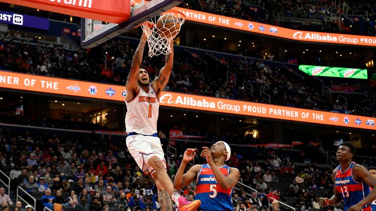 New York Knicks forward Obi Toppin dunks over Washington Wizards guard Cassius Winston as center Thomas Bryant watches 
