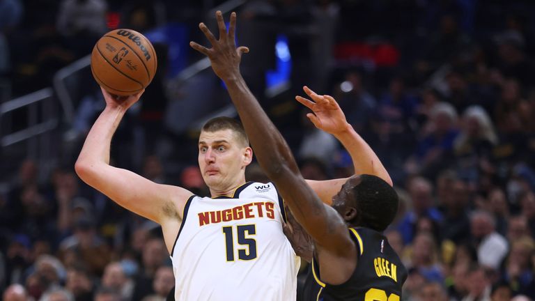 Denver Nuggets center Nikola Jokic (15) passes the ball as Golden State Warriors forward Draymond Green (23) defends during the first half of Game 5 of an NBA basketball first-round playoff series in San Francisco, Wednesday, April 27, 2022. (AP Photo/Jed Jacobsohn)