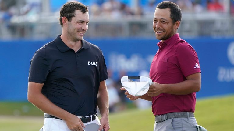 Patrick Cantlay laughs with teammate Xander Schauffele, right, on the 18th green after completing their third round of the PGA Zurich Classic golf tournament, Saturday, April 23, 2022, at TPC Louisiana in Avondale, La. (AP Photo/Gerald Herbert)