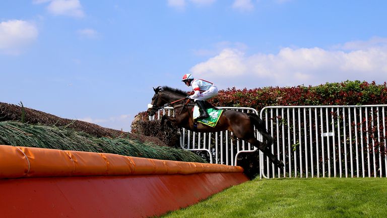 Saint Calvados clears a fence on his way to winning the Oaksey Chase at Sandown