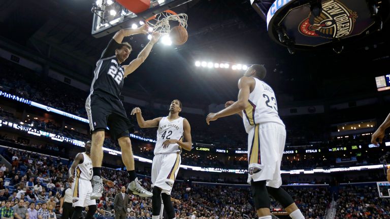 San Antonio Spurs center Tiago Splitter slam dunks over New Orleans Pelicans center Alexis Ajinca and Anthony Davis