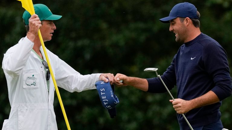 Scottie Scheffler pumps fist with his caddie Ted Scott after putting on the 11th green during the second round at the Masters golf tournament on Friday, April 8, 2022, in Augusta, Ga. (AP Photo/Matt Slocum)