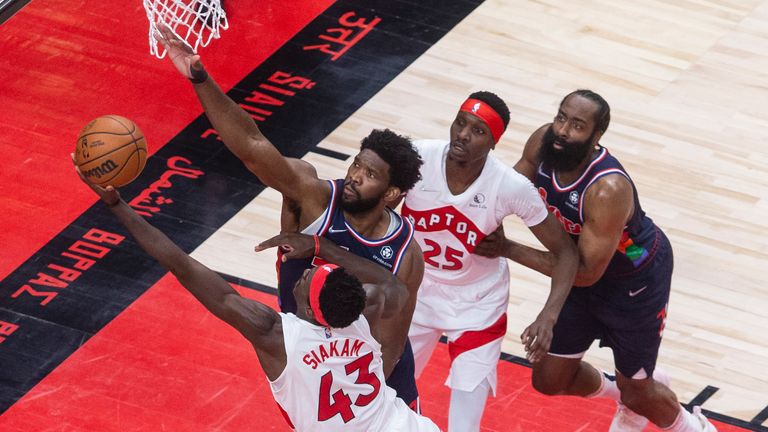 El alero de los Toronto Raptors, Pascal Siakam, recibe una falta de los Philadelphia 76ers'  Joel Embiid como Raptors'  Chris Boucher y los 76ers'  James Harden mira durante el Juego 4 de una serie de playoffs de primera ronda de baloncesto de la NBA