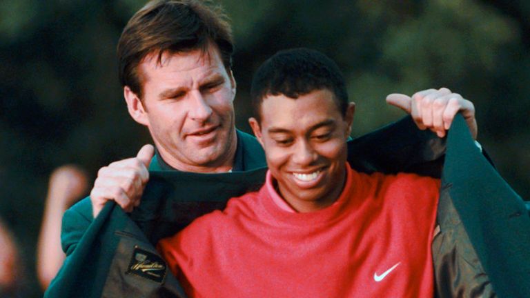Woods receives is presented with his first Green Jacket by Nick Faldo in 1997