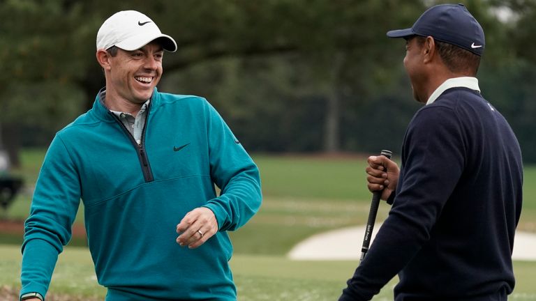 Tiger Woods is greeted by Rory McIlroy during a practice round for The Masters 