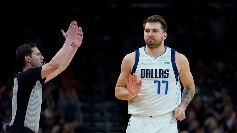 Dallas Mavericks guard Luka Doncic, front, works the ball against Phoenix Suns guard Devin Booker (1) during the first half of Game 3 of an NBA basketball second-round playoff series, Friday, May 6, 2022, in Dallas. (AP Photo/Tony Gutierrez)