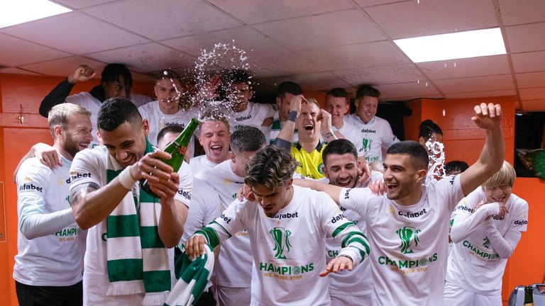 The Celtic players celebrate winning the title at Tannadice