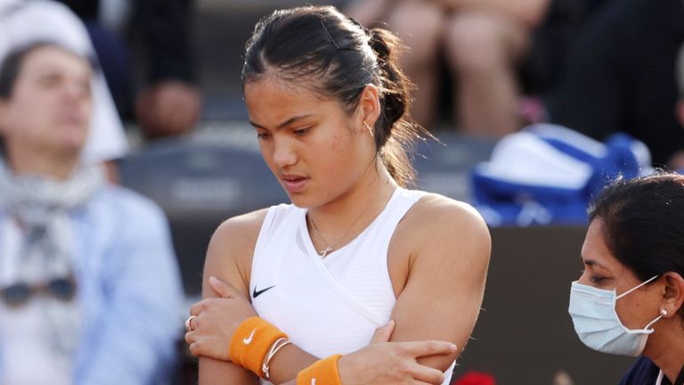 Emma Raducanu receives treatment on court for a back injury that forced her to retire from her first-round match