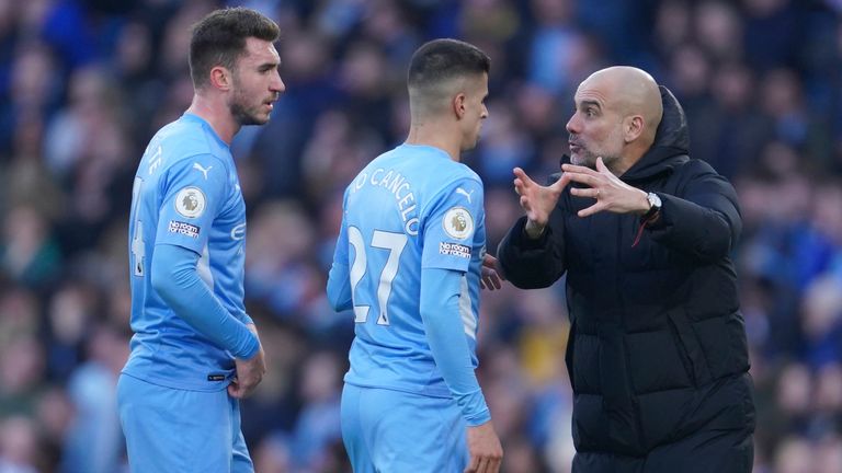 Manchester City&#39;s head coach Pep Guardiola, right, gives instructions to his players Joao Cancelo, second right, and Manchester City&#39;s Aymeric Laporte during the English Premier League soccer match between Manchester City and Manchester United, at the Etihad stadium in Manchester, England, Sunday, March 6, 2022. 