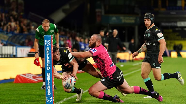 Huddersfield Giants&#39; Jake Wardle scores their side&#39;s fourth try of the game as Wigan Warriors&#39; Jake Bibby tries to tackle during the Betfred Super League match at John Smith&#39;s Stadium