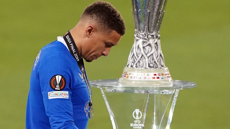 James Tavernier walks past the Europa League trophy with his runner-up medal