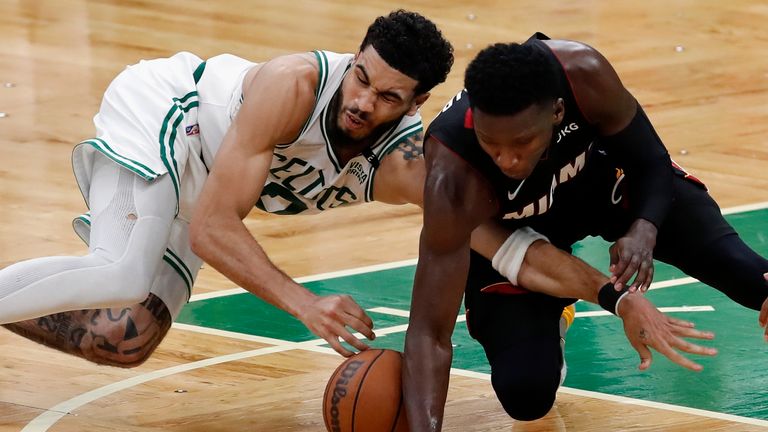 Boston Celtics forward Jayson Tatum battles Miami Heat guard Victor Oladipo for a loose ball during the second half of Game 3