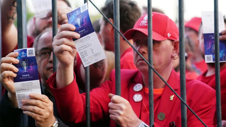 Liverpool supporters show off tickets as they struggle to reach the Champions League final