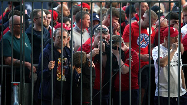 Pendukung menutupi wajah mereka saat mereka mencoba masuk ke Stade de France. Ada laporan polisi menggunakan semprotan merica