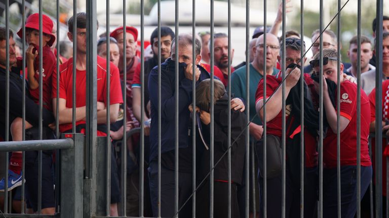 Los fanáticos se cubren la cara mientras intentan ingresar al Stade de France.  Hubo informes de que la policía usó gas pimienta.