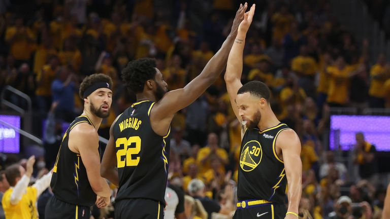 Golden State Warriors forward Andrew Wiggins (22) celebrates with guard Stephen Curry (30) and guard Klay Thompson, left, during the first half of Game 1 of the NBA basketball playoffs Western Conference finals against the Dallas Mavericks in San Francisco, Wednesday, May 18, 2022.