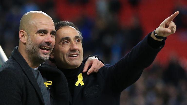 Pep Guardiola manager of Manchester City and assistant Manuel Estiarte wear pro Catalan ribbons during the Carabao Cup Final between Arsenal and Manchester City at Wembley Stadium on February 25, 2018 in London, England