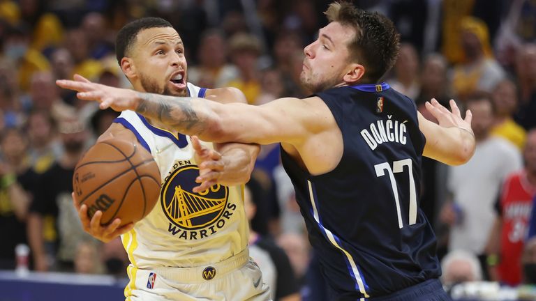 Golden State Warriors guard Stephen Curry, left, shoots against Dallas Mavericks guard Luka Doncic during the second half of Game 2