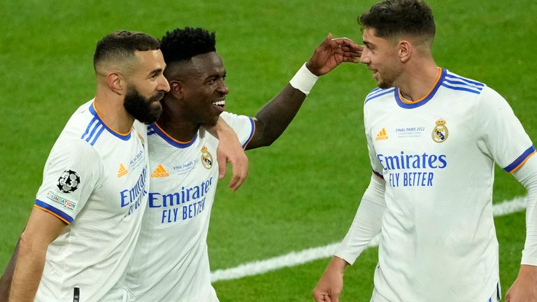Real Madrid&#39;s Vinicius Junior, center, celebrates with Real Madrid&#39;s Karim Benzema, left, and Real Madrid&#39;s Federico Valverde after scoring his side&#39;s opening goal during the Champions League final soccer match between Liverpool and Real Madrid at the Stade de France in Saint Denis near Paris, Saturday, May 28, 2022. (AP Photo/Christophe Ena)