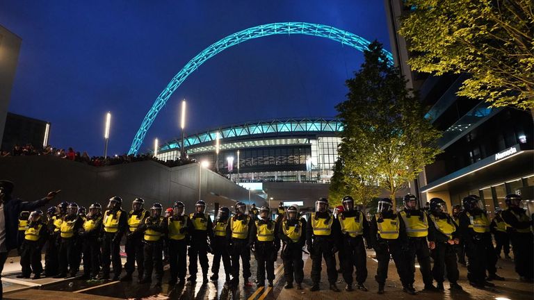 Polis, Temmuz 2021'de İngiltere ile İtalya arasında oynanacak Euro 2020 finali öncesinde biletsiz taraftarlar tarafından ihlal edilen Wembley Stadyumu çevresinde bir kordon oluşturuyor.