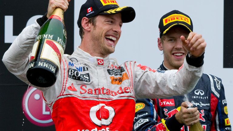 McLaren Mercedes driver Jenson Button, of Britain, celebrates his victory as second-place Red Bull driver Sebastian Vettel, of Germany, looks on following the Canadian Grand Prix auto race, Sunday, June 12, 2011 in Montreal. 