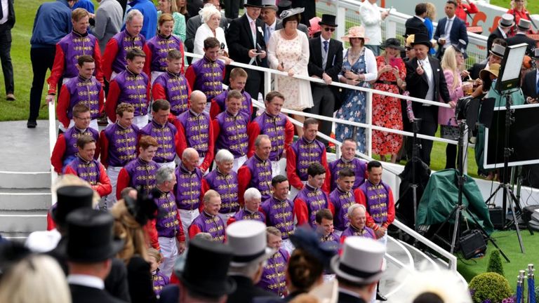 Jockeys pose for a special photo at Epsom wearing the Queen's silks
