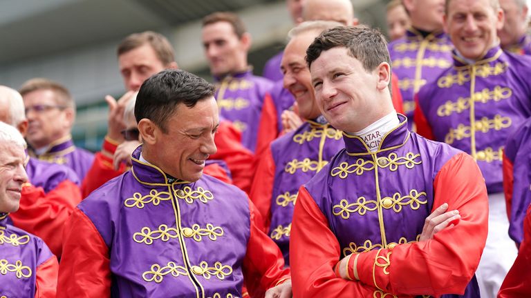 Frankie Dettori and Oisin Murphy share a joke as jockeys past and present pose for a special photo in honour of the Queen's Platinum Jubilee