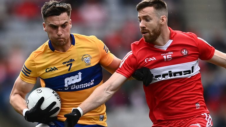 Jamie Malone of Clare in action against Niall Loughlin of Derry