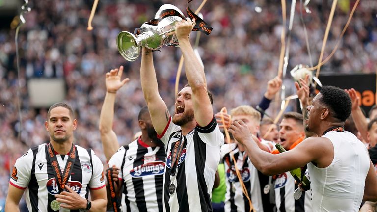 Grimsby Town's Luke Waterfall lifts the National League final trophy 