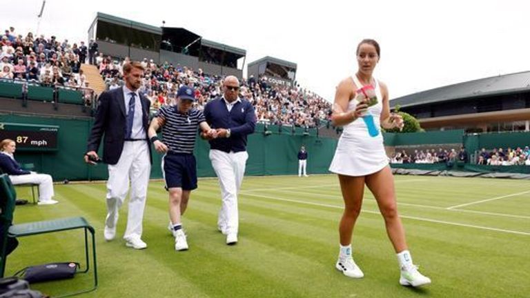 A ball boy is helped off court during the Ladies' singles first round match between Jodie Burrage and Lesia Tsurenko during day one of the 2022 Wimbledon Championships at the All England Lawn Tennis and Croquet Club, Wimbledon. Picture date: Monday June 27, 2022.
