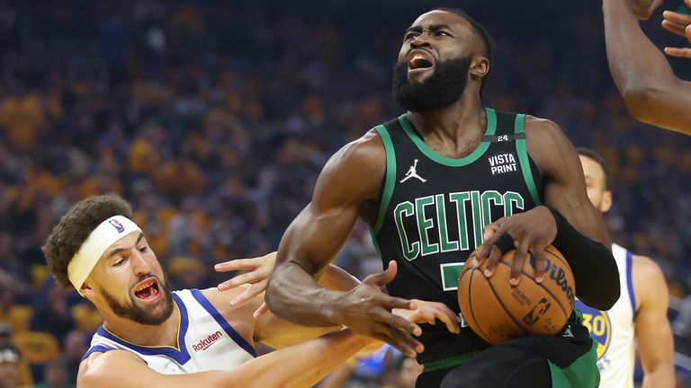 Golden State Warriors forward Andrew Wiggins (22) shoots against Boston Celtics guard Jaylen Brown (7) and forward Jayson Tatum (0) during the first half of Game 5 of basketball&#39;s NBA Finals in San Francisco, Monday, June 13, 2022.