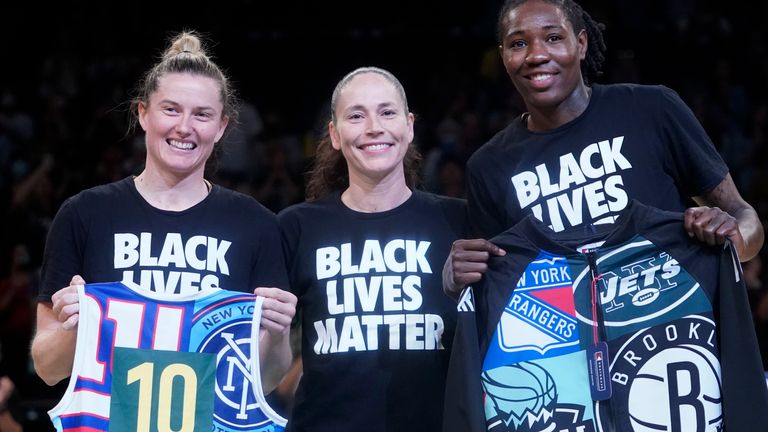 Seattle Storm guard Sue Bird, center, poses for a photo with former Storm teammates, New York Liberty forward Natasha Howard, left, and guard Sami Whitcomb